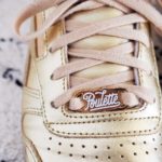 lace lock poulette écriture blanche sur une basket dorée